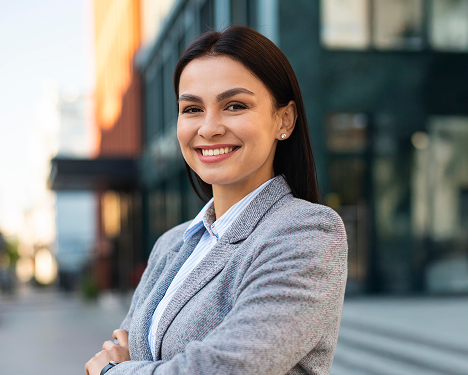 smiley-businesswoman-posing-city-with-arms-crossed 1